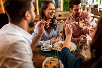 Friends Playfully Feeding Woman at Restaurant Lunch