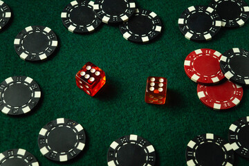 Bright red and black dice sit among various poker chips on a green felt table, capturing the excitement of a casino game night where players enjoy their luck