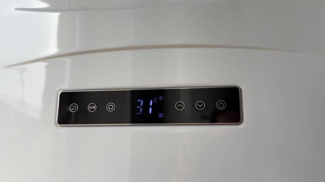 Electronic display with touch control buttons on the gas boiler. Man or woman turns on the heating
