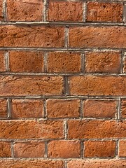 Textured red brick wall background in warm tones, rustic and urban style, construction concept 