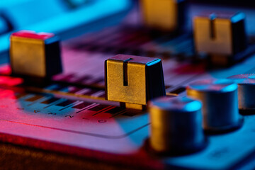Retro audio mixer console closeup with neon lights. Concept of sound engineering, podcast cover art, retro music lifestyle, streaming visuals, and creative advertising posters.
