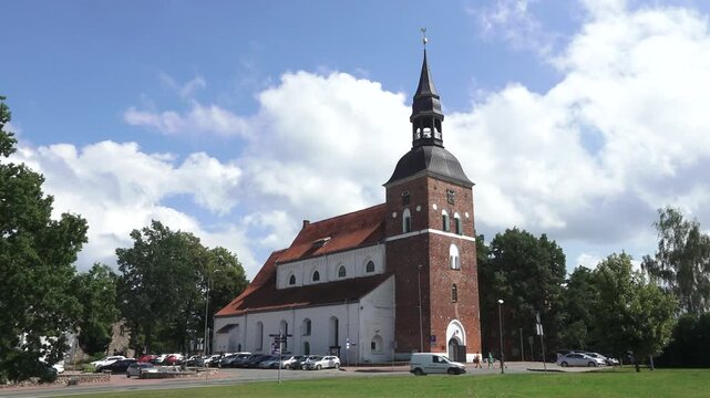 Historic Brick and White Church With Tower in Sunny Green Surroundings