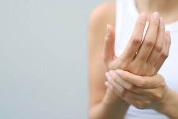 young woman hand pain her wrist.  injury, feeling pain from cramp, trigger finger,  touching massaging,  ache joint. Health care and medical concept. 