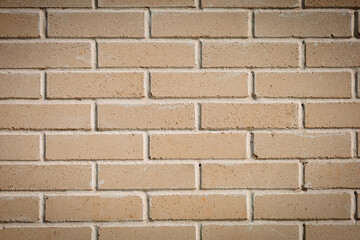A smooth brick wall made of light clinker brick. The bricks are laid in a checkerboard pattern, the seams between them are neat. The wall surface is smooth, without defects.
