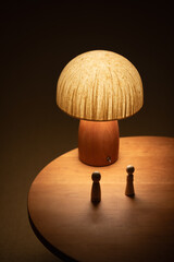 A pair of puppets sit on a wooden table. Under a mushroom lamp, they stare at each other. An emotional scene. table lamp on a table