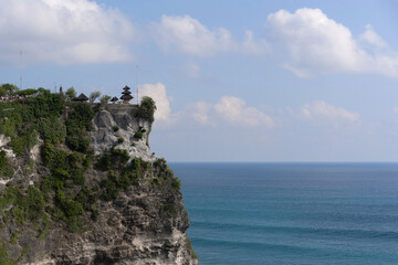 Pura Luhur Uluwatu, a Balinese Hindu sea temple perched on a steep cliff in Bali, Indonesia, with the vast blue ocean in the background.
