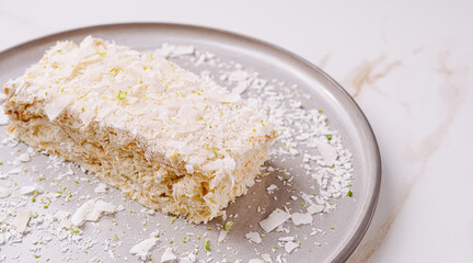 Coconut dessert on a silver plate with shredded coconut topping