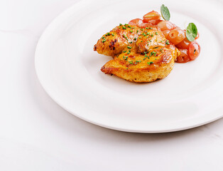 Delicious baked chicken dish served with cherry tomatoes and herbs
