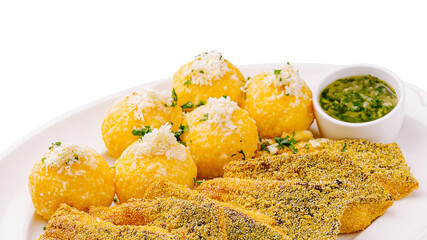 Crispy fish with golden balls served with green sauce and herbs