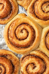 Freshly baked cinnamon rolls on a baking sheet top view. Making cinnamon rolls process. Cinnabon preparation