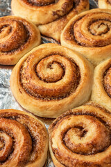 Freshly baked cinnamon rolls on a baking sheet. Making cinnamon rolls process. Cinnabon preparation