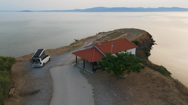 Aerial Helix Drone Shot Of Campervan On Hazy Coastline Off Kassandra, Halkidiki, Greece At Sunrise.