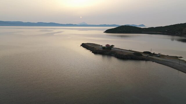 Aerial Drone Shot Flying Over The Calm Aegean Sea Off Kassandra, Halkidiki, Greece At Sunrise On A Hazy Morning.