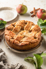 Homemade Apple Pie with fresh apples on textured background. Thanksgiving traditional dessert, autumn baking, recipe