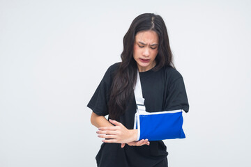 A distressed young Asian woman captured in a half body shot wearing an arm sling, showing visible...