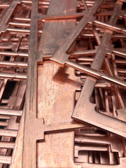 Copper plate with sections cut out waste from a manufacturing process ready to be recycled