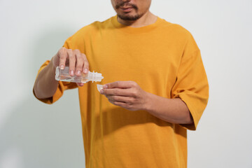 A man carefully uses eye drops or an eye wash solution, focusing on his eye health and personal hygiene routine to maintain clear and comfortable vision.