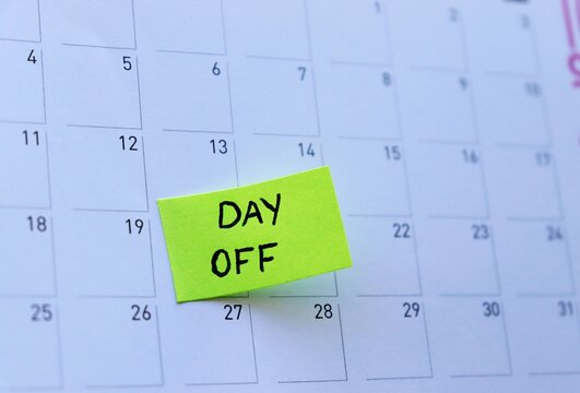 Day Off Marked on Calendar. Sticky Note Reminder. Workplace message in the office. Concept of absence from work and day off.