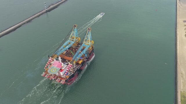 Large pipelay crane ship cruising Rotterdam waters in daylight, Netherlands