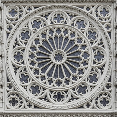 a white ornate window with a circular design
