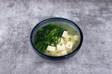 Spinach and tofu soup in a porcelain bowl