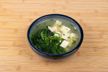 Spinach and tofu soup in a porcelain bowl