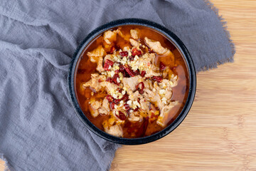 Sichuan-style boiled meat slices in a porcelain bowl
