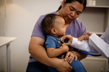 An overweight Asian woman brings her one-year-old son to consult a health expert in a private office. The scene emphasizes family care, professional guidance, wellness improvement