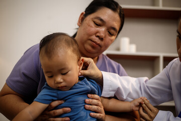 An overweight Asian woman brings her one-year-old son to consult a health expert in a private office. The scene emphasizes family care, professional guidance, wellness improvement