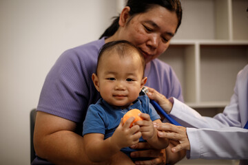 An overweight Asian woman brings her one-year-old son to consult a health expert in a private office. The scene emphasizes family care, professional guidance, wellness improvement