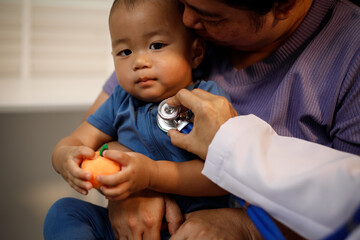 An overweight Asian woman brings her one-year-old son to consult a health expert in a private office. The scene emphasizes family care, professional guidance, wellness improvement