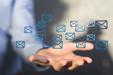 Hand holding digital email icons, representing global communication and networking.