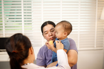 An overweight Asian woman brings her one-year-old son to consult a health expert in a private office. The scene emphasizes family care, professional guidance, wellness improvement