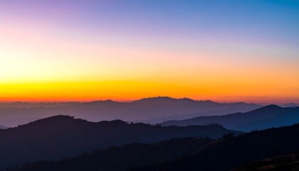 Obraz premium A breathtaking sunrise paints the mountain ranges in hues of orange, purple, and blue, creating a serene and majestic view.
