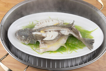 Steamed sea bass in a steaming pot