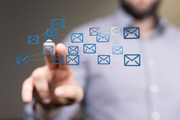 Hand pointing at network of email icons.  Digital communication, global connectivity, teamwork.