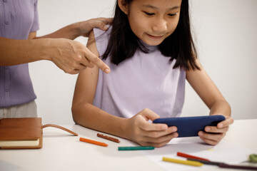 Asian mother spends warm, loving moments with her 10-year-old daughter in cozy room, highlighting family bonding, emotional connection, care, support, beauty of unconditional love and togetherness.