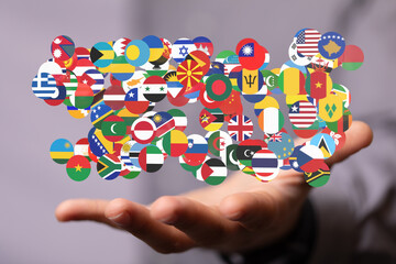 Image of a hand holding various national flags, symbolizing global unity and international relations.