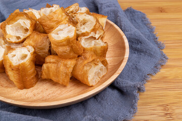 Handmade fried dough sticks in a wooden plate
