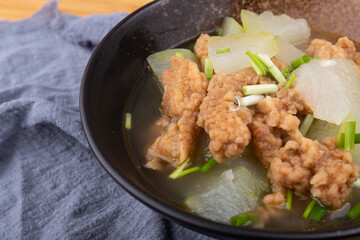 The winter melon and meat soup dish in a porcelain bowl