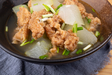 The winter melon and meat soup dish in a porcelain bowl