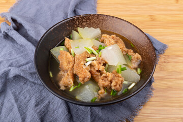 The winter melon and meat soup dish in a porcelain bowl