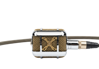 Classic, ornate vintage studio microphone with polished chrome body & brass grille, dark braided cable, horizontal on transparent studio background, copy space. Concept of nostalgic sound and