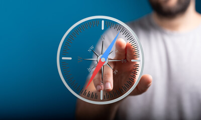 Conceptual image of a man using a digital compass to find direction and make strategic decisions.