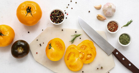 Board with fresh tomatoes and peppercorn on white background