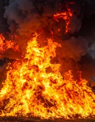 Intense Flames Rising with Dark Smoke During Outdoor Burning Event Showing Devastation
