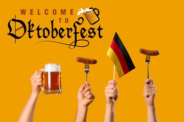 Hands with beer and sausages on orange background. Octoberfest celebration