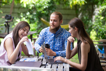 Group of business professionals analyzing colorful charts and graphs during an outdoor meeting, showcasing teamwork, data-driven decision-making, and creative corporate strategy.