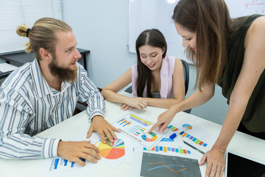 Diverse business team in meeting room discussing project strategy with charts and tablet, showing teamwork, planning, and collaboration in a modern corporate environment. - Powered by Adobe