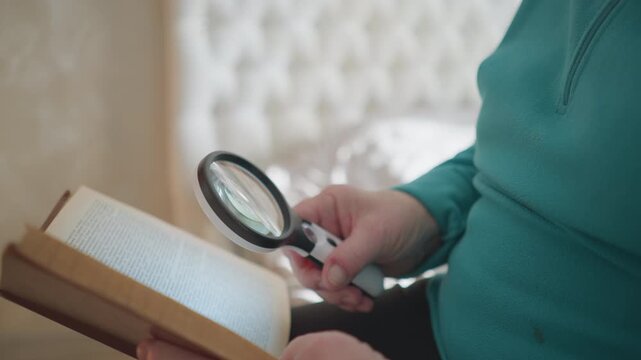 Senior woman reading book with magnifying glass, carefully examining text. Bright, cozy indoor setting with soft natural light illuminating pages, enhancing readability